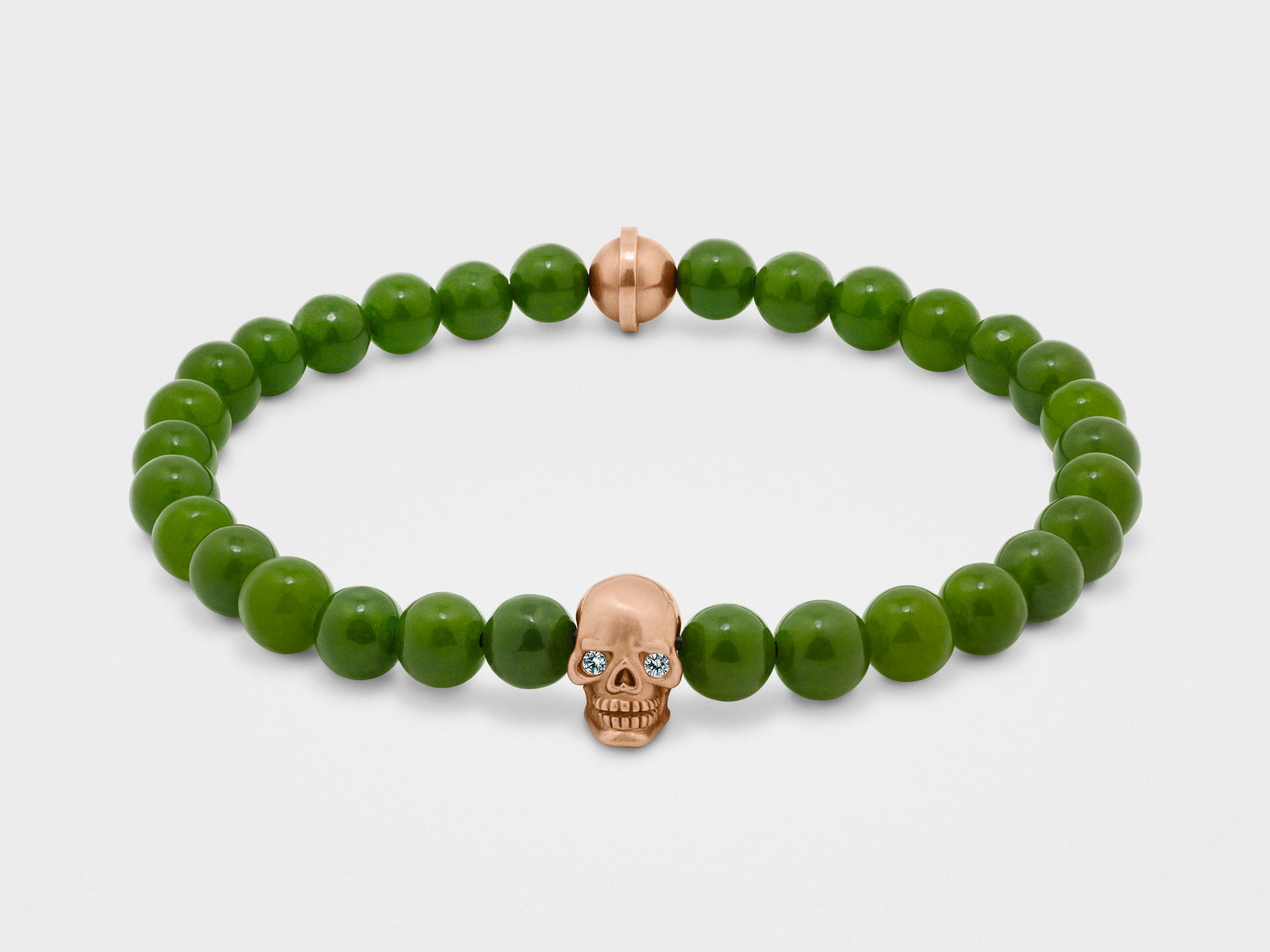 Bracelet tête de mort en or avec yeux clairs et perle verte