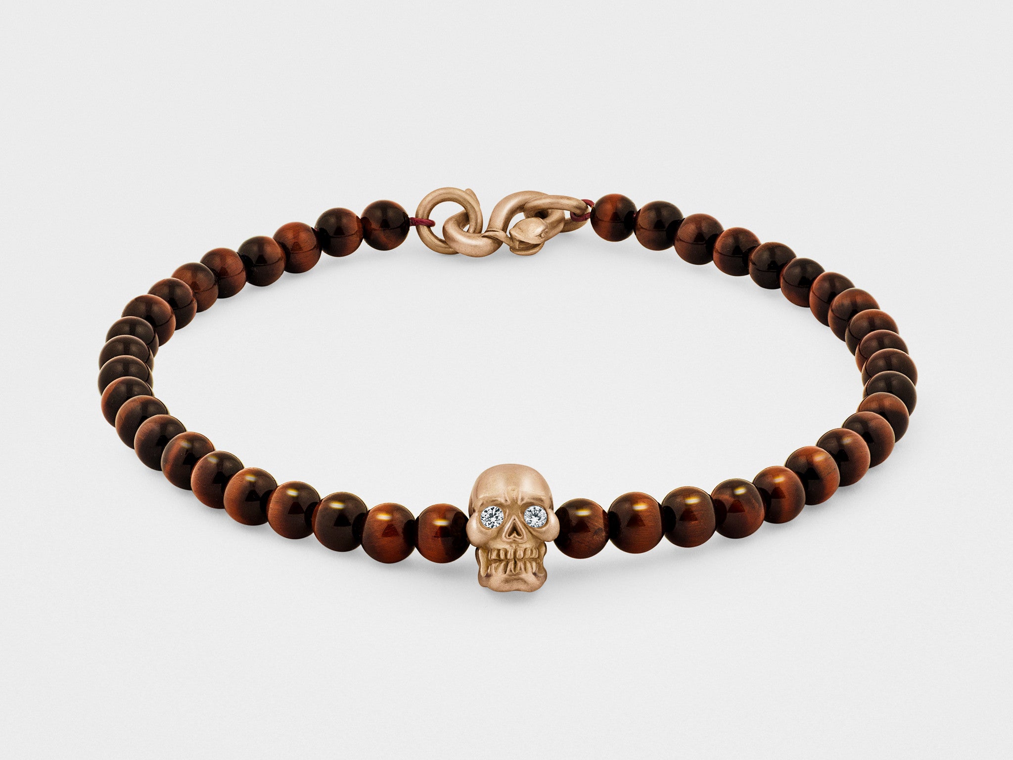 Bracelet tête de mort en or avec yeux transparents, perle rouge et fermoir serpent