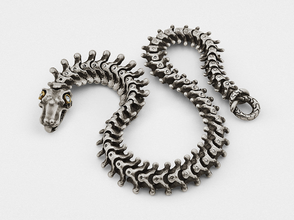 Bracelet en os de serpent argenté et doré orné d'un cristal clair